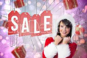 Composite image of cute brunette in santa claus smiling at camer