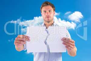 Composite image of man holding torn white paper