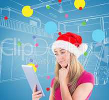 Composite image of festive blonde looking at tablet pc