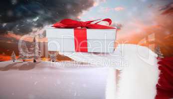 Composite image of santa claus showing gift with red ribbon