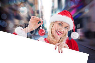 Composite image of festive blonde showing white card