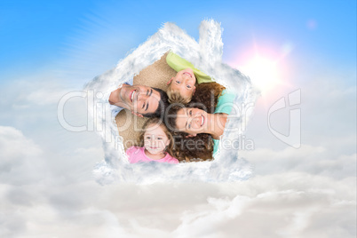 Composite image of happy family lying on the rug in a circle