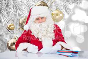 Composite image of santa writing cards