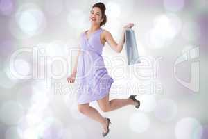 Composite image of happy brunette jumping with shopping bag