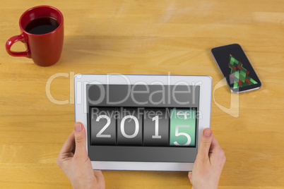 Composite image of businesswoman using tablet at desk