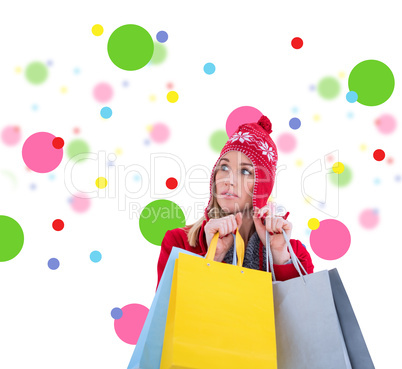 Composite image of blonde in winter clothes holding shopping bag