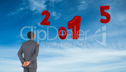 Composite image of young businessman standing with suitcase