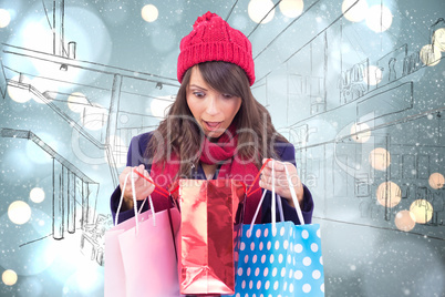 Composite image of shocked brunette opening gift bag