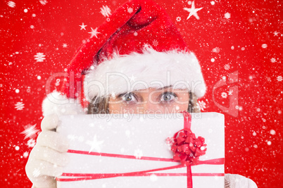 Composite image of festive blonde holding a gift