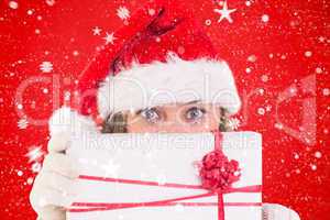 Composite image of festive blonde holding a gift