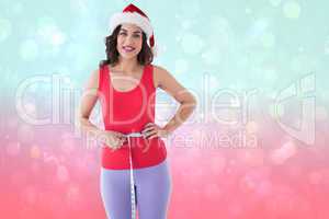Composite image of festive athletic brunette measuring her waist