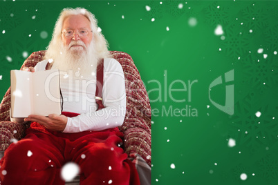 Composite image of father christmas showing a book