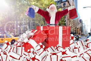 Composite image of santa standing in large gift