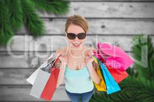 Composite image of woman holding shopping bags wearing sunglasse