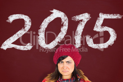 Composite image of unhappy brunette opening christmas gift