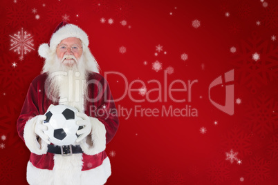 Composite image of santa holds a classic football