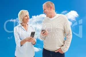 Composite image of happy mature couple using their smartphones