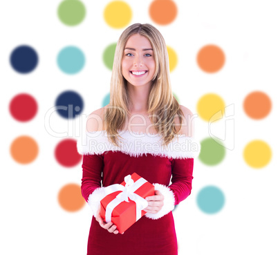 Composite image of pretty santa girl holding gift