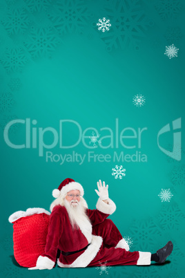 Composite image of santa sits leaned on his bag and waves