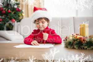 Composite image of festive little boy writing wish list