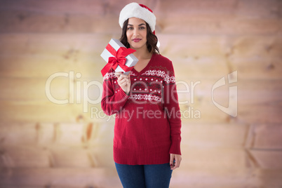 Composite image of pretty brunette showing christmas present