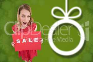 Composite image of surprised blonde showing a red sale poster