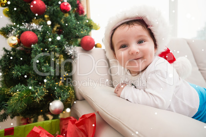 Composite image of cute baby boy on couch at christmas