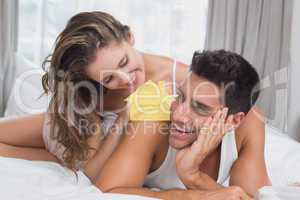 Composite image of romantic young couple in bed at home