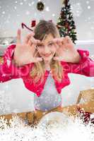 Composite image of festive little girl making christmas cookies