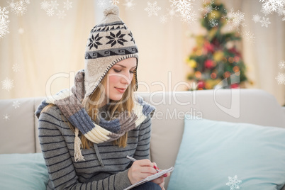 Composite image of pretty blonde with winter hat on writing on h