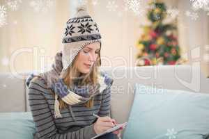 Composite image of pretty blonde with winter hat on writing on h
