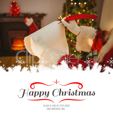 Composite image of father christmas writing with a quill