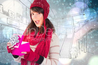 Composite image of festive brunette holding a gift