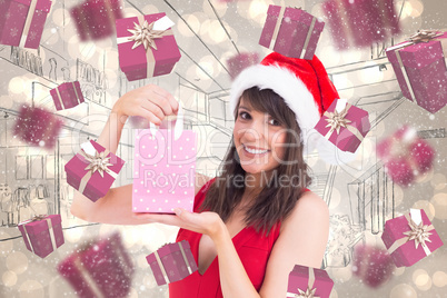 Composite image of festive brunette holding a gift bag