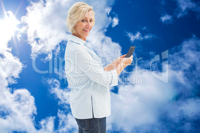 Composite image of happy mature woman sending a text