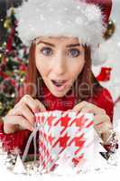 Composite image of festive redhead opening christmas gift