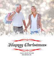 Composite image of happy couple with shopping bags