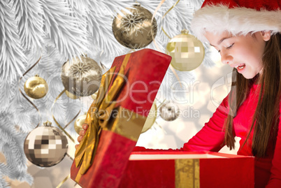 Composite image of little girl opening gift