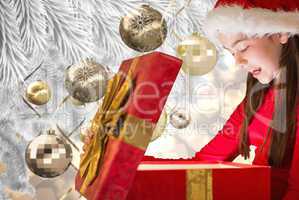 Composite image of little girl opening gift