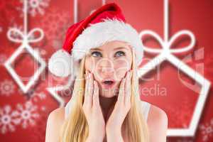 Composite image of festive blonde looking surprised with hands o