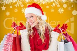 Composite image of happy festive blonde with shopping bags