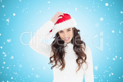 Composite image of confused brunette in santa hat