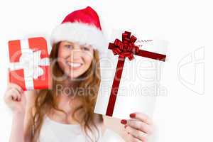 Composite image of festive redhead holding a gift