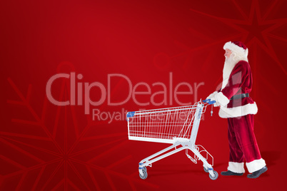 Composite image of santa pushes a shopping cart