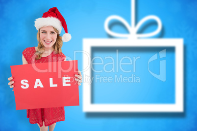 Composite image of pretty blonde in santa hat holding a red sale