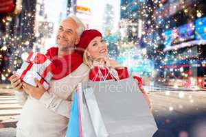 Composite image of happy festive couple with gifts and bags