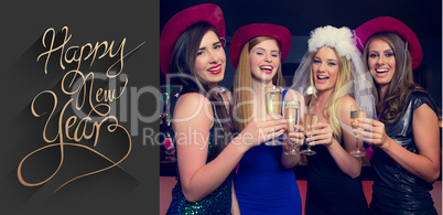 Composite image of laughing friends clinking champagne glasses a