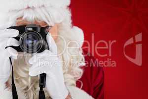 Composite image of portrait of santa taking a photo