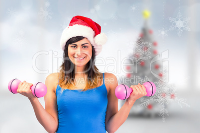 Composite image of festive fit brunette holding dumbbells