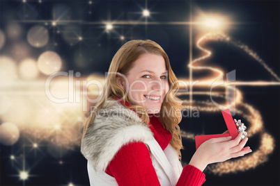 Composite image of surprised woman opening gift while looking at